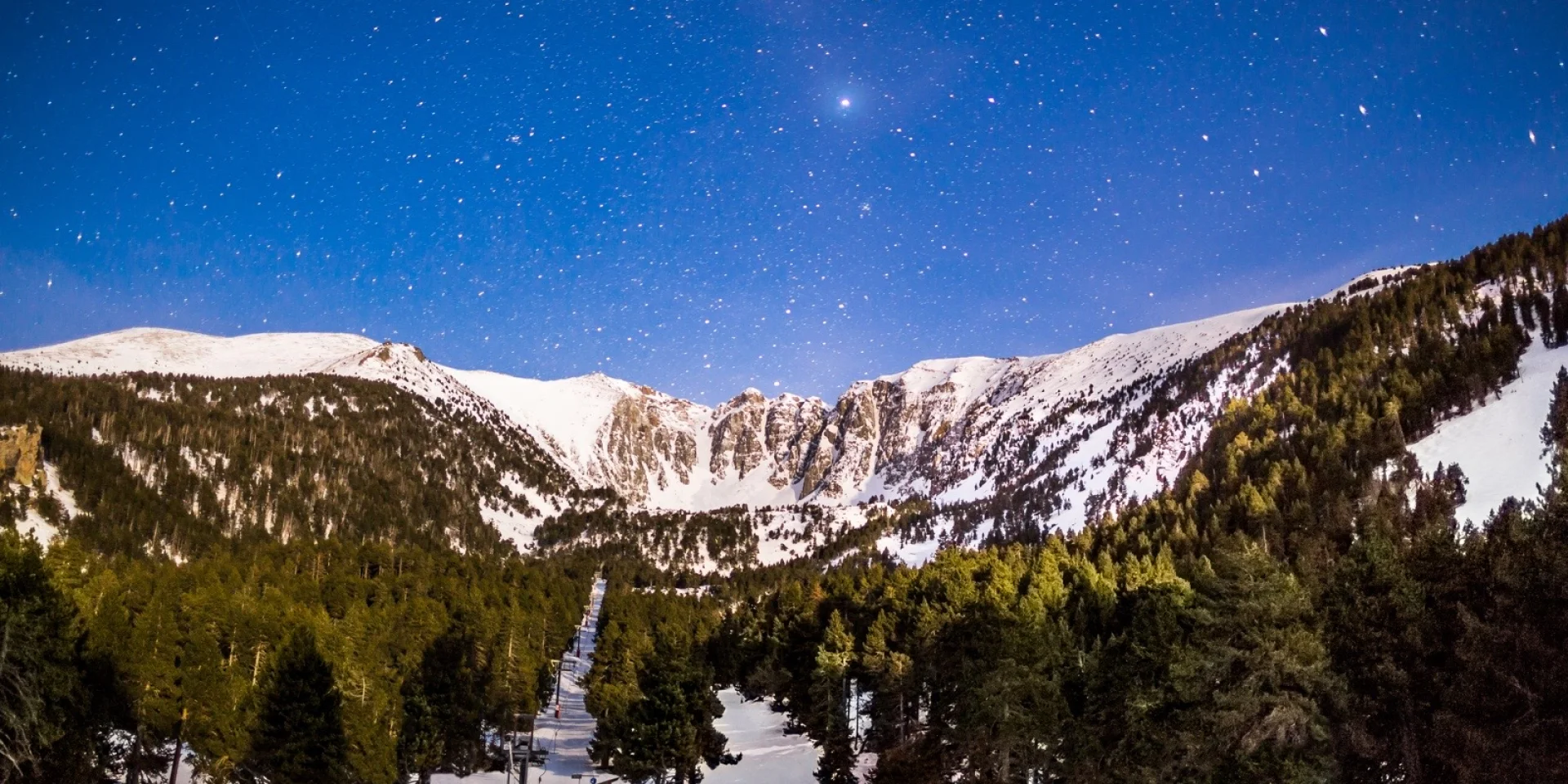 Le massif du Cambre d’Aze sous un ciel étoilé, photographié de nuit depuis la station d’Eyne lors d’une randonnée en raquettes dans les Pyrénées Catalanes.